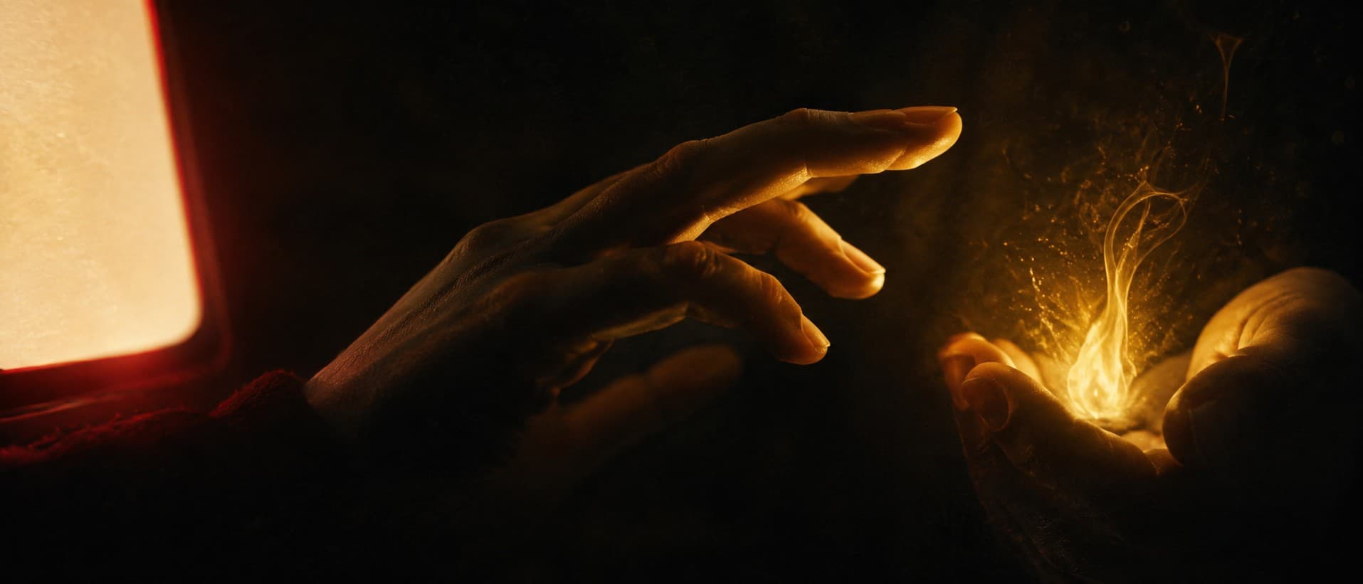 An intimate close shot of a single human hand paused mid-reach in the dark, suspended between a cold flat machine glow on one side and a small warm living aurum flame cupped in shadow on the other, the fingers turning toward the inner flame, choosing it first.